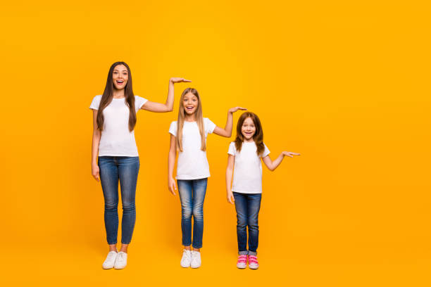 Three girls are comparing their height.